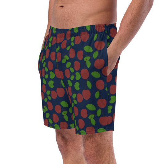 front view of model wearing cherry swim trunks in navy