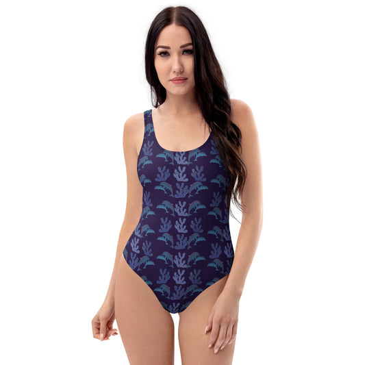  front view of model wearing coral reef dolphins one piece swimsuit in purple