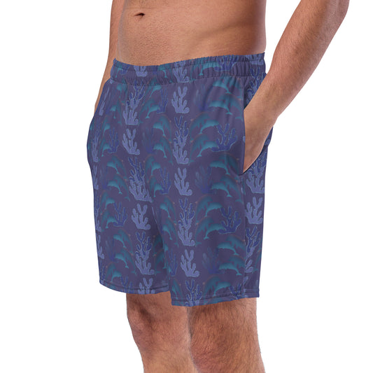 left front view of model wearing coral reef dolphins swim trunks in purple blue