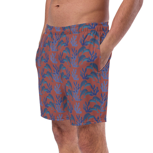 left front view of model wearing coral reef dolphins swim trunks in terracotta